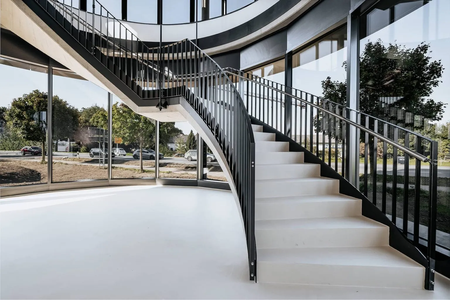 Wendeltreppe mit fugenloser Oberfläche und Rundumverglasung